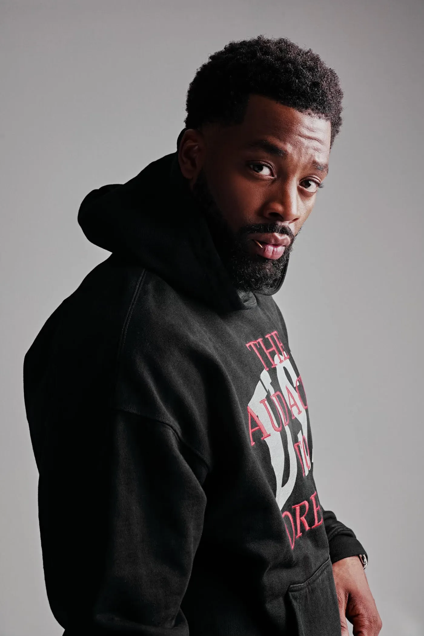 LaRoyce Hawkins in a black hoodie looking over his shoulder